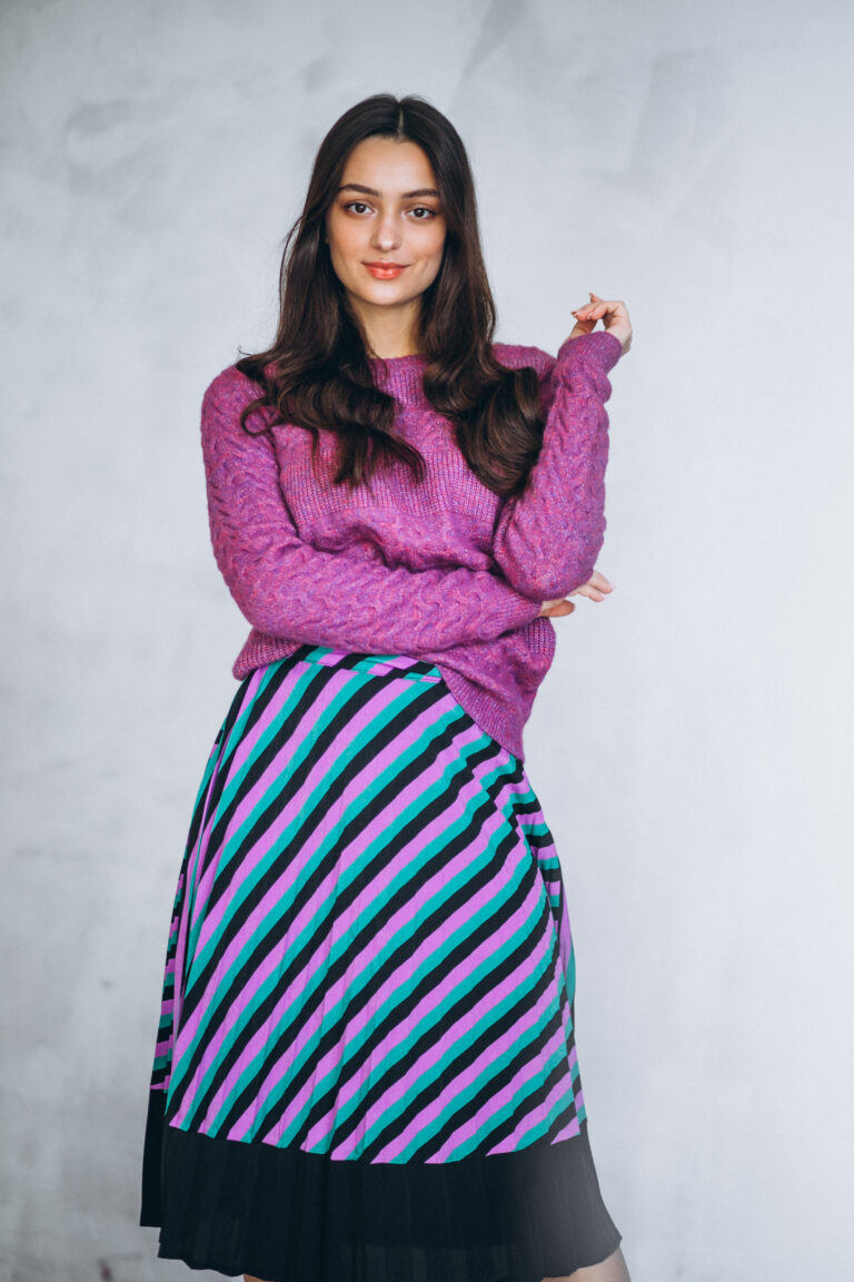 Beautiful woman in a purple sweater and skirt in studio